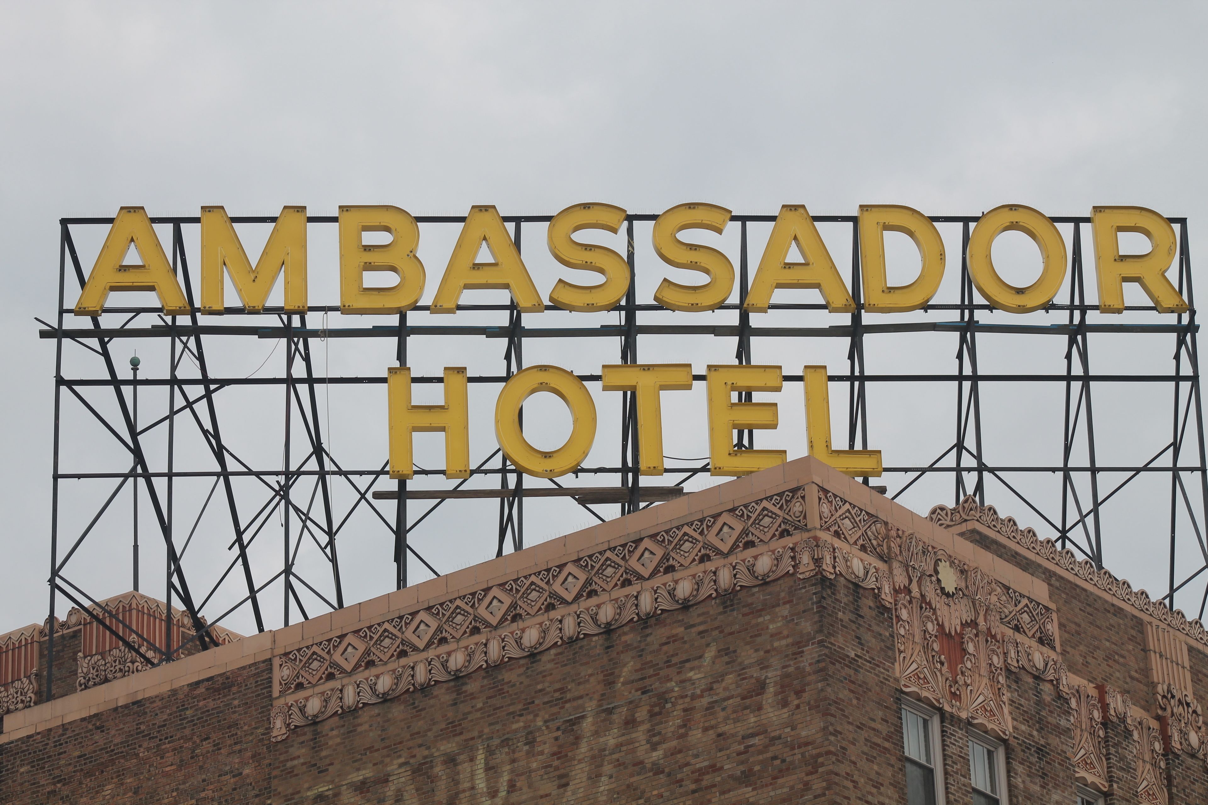 A large sign for the Ambassador Hotel with a decorative architectural facade.