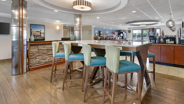 A modern bar area with a central island, bar stools, and a stone accent wall.