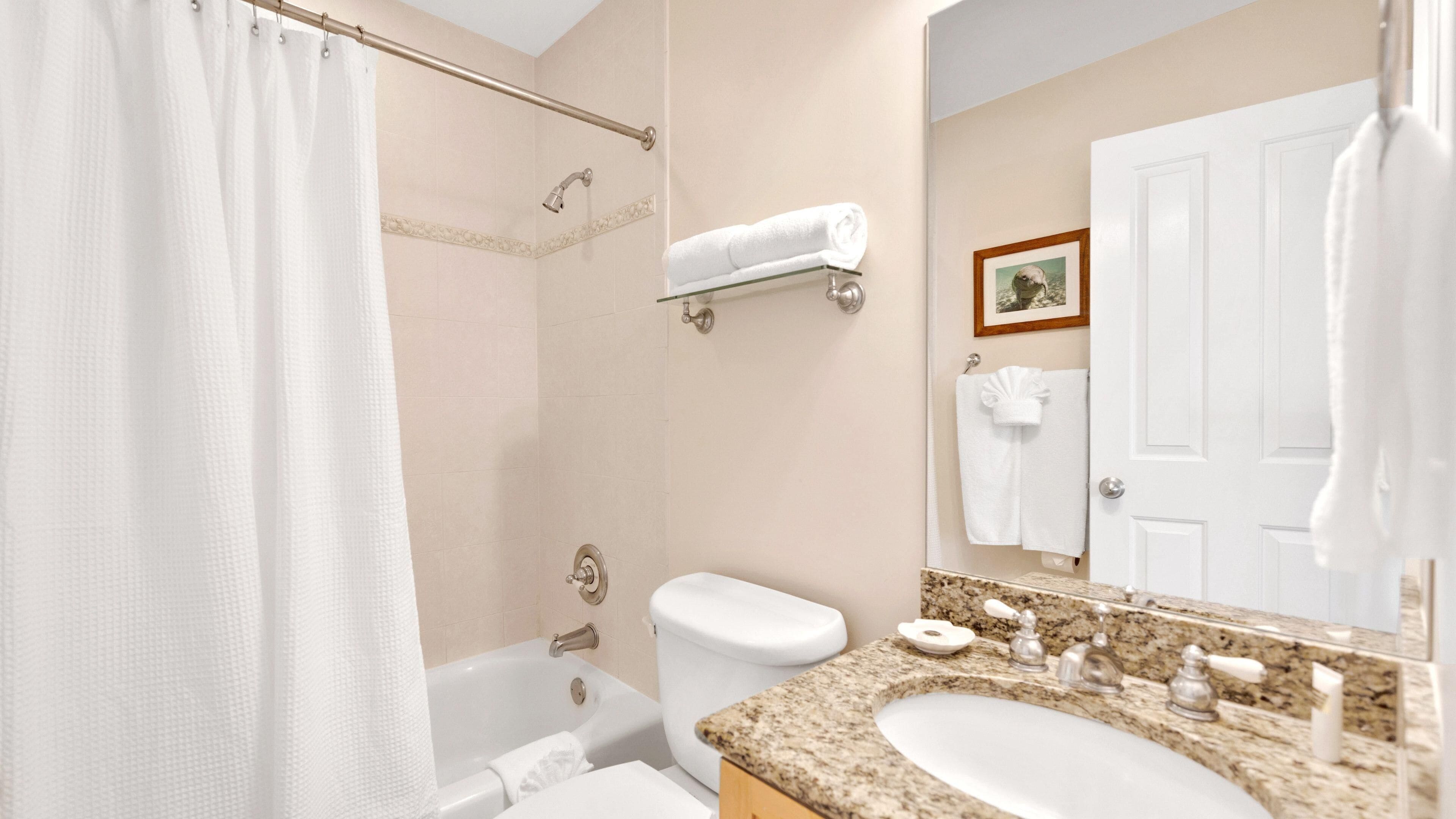 A bathroom with a shower, toilet, and sink.