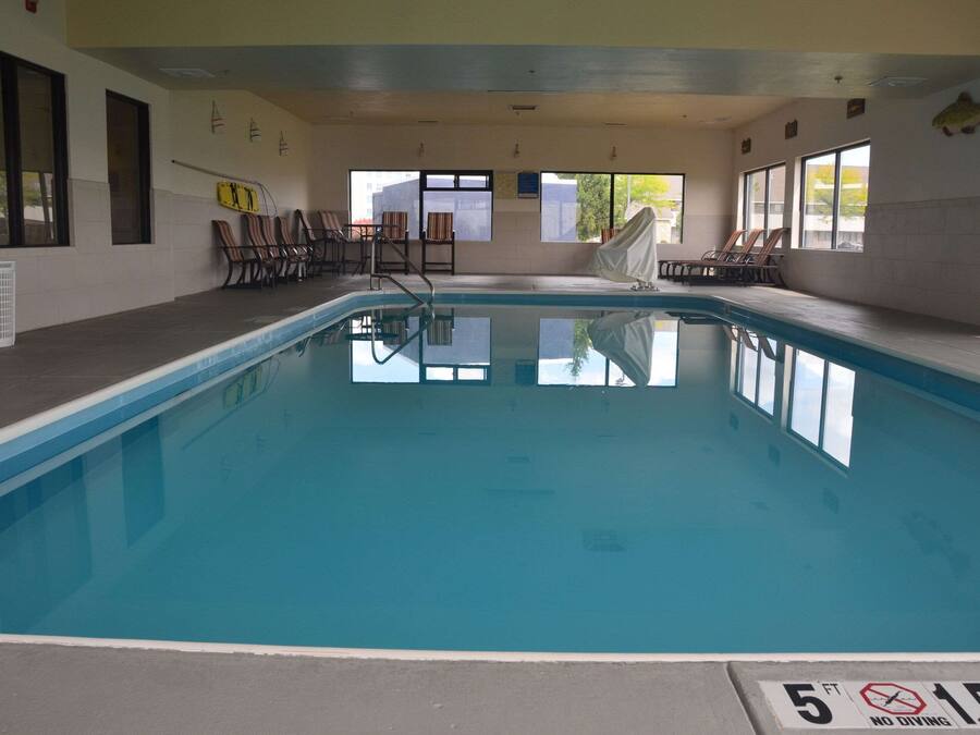 An indoor swimming pool with clear water, a no diving sign, and a 5 ft depth limit.