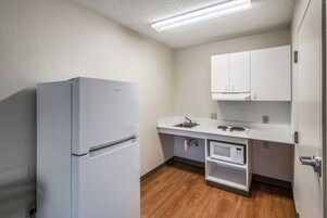 Una cocina compacta equipada con refrigerador, microondas y pileta.