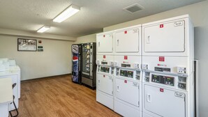 Une rangée de distributeurs automatiques et une rangée de sèche-linge dans une chambre d’hôtel.