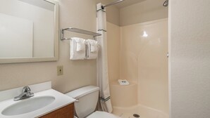 A bathroom with a sink, toilet, shower, and a towel rack. - HomeTowne Studios by Red Roof Spokane - Valley (Spokane Valley)