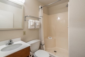A bathroom with a sink, toilet, and shower. - HomeTowne Studios by Red Roof Spokane - Valley (Spokane Valley)