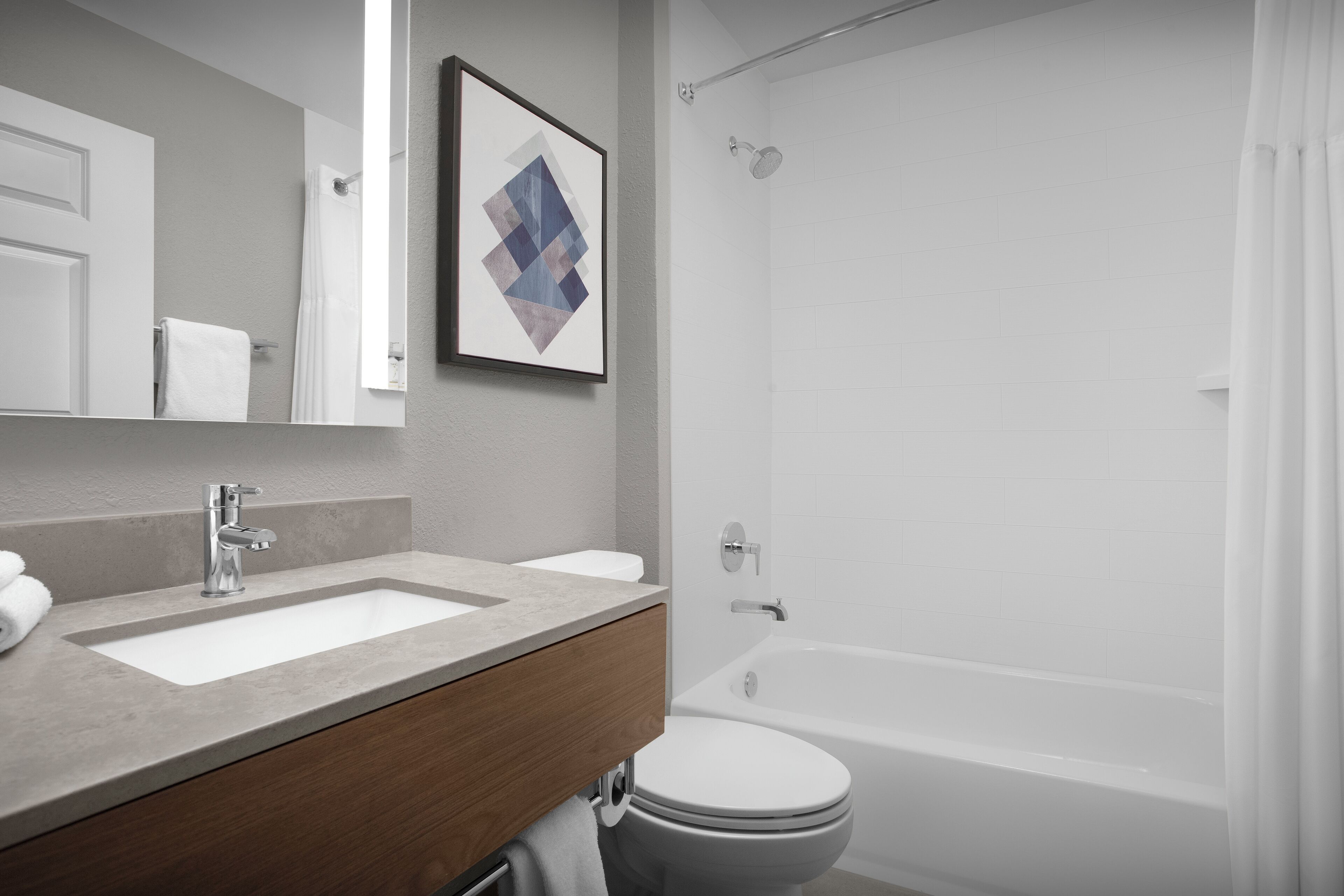 Een badkamer met een dubbele wastafel, toilet en bad.