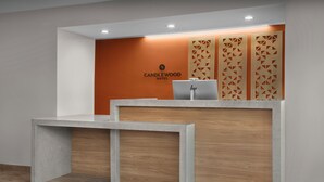 Un mostrador de recepción de diseño moderno, con un logotipo y un ordenador portátil.