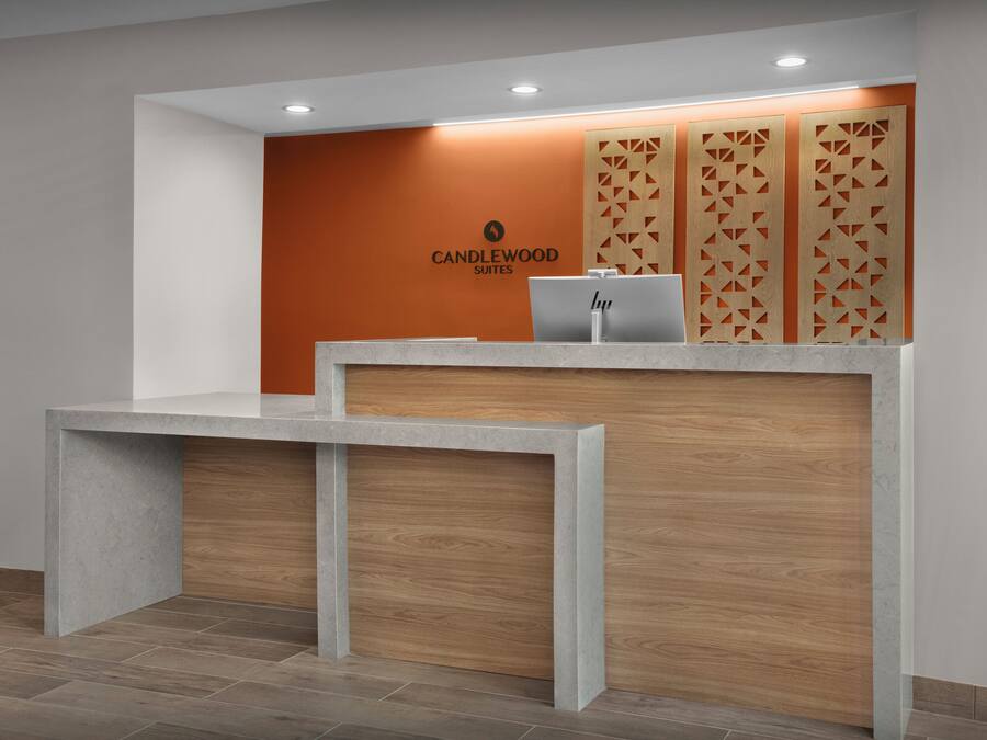 Un mostrador de recepción de diseño moderno, con un logotipo y un ordenador portátil.