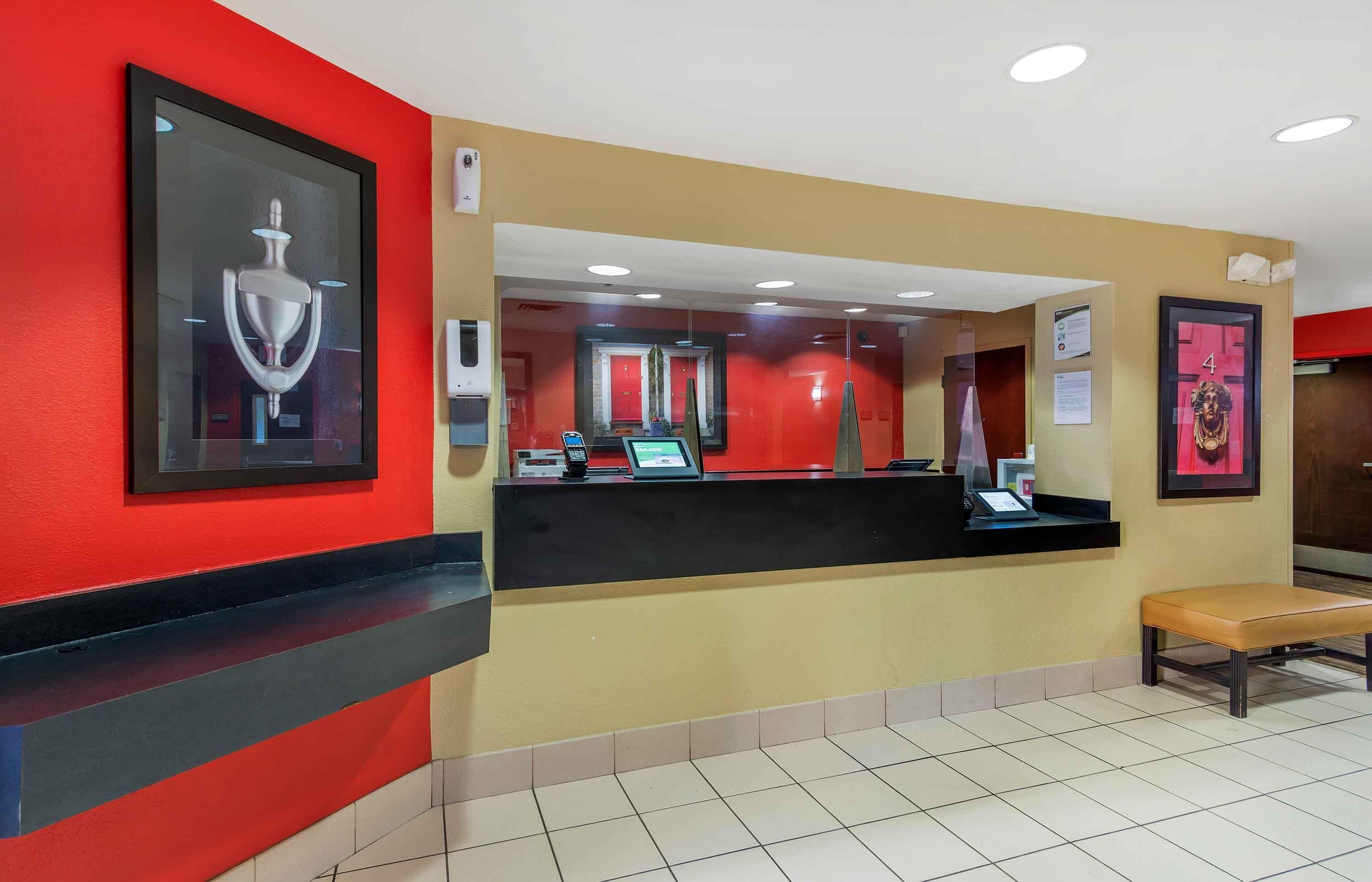A reception area with a black counter, a bench, and a framed picture on the wall.