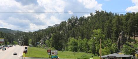 A roadside view with a gelato stand, a gazebo, and a mountain backdrop.
