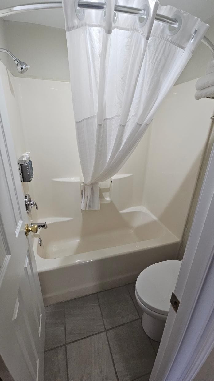 A bathroom with a bathtub, toilet, and shower curtain.