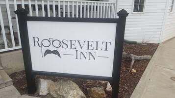 Letrero del Roosevelt Inn con un dibujo de bigote.