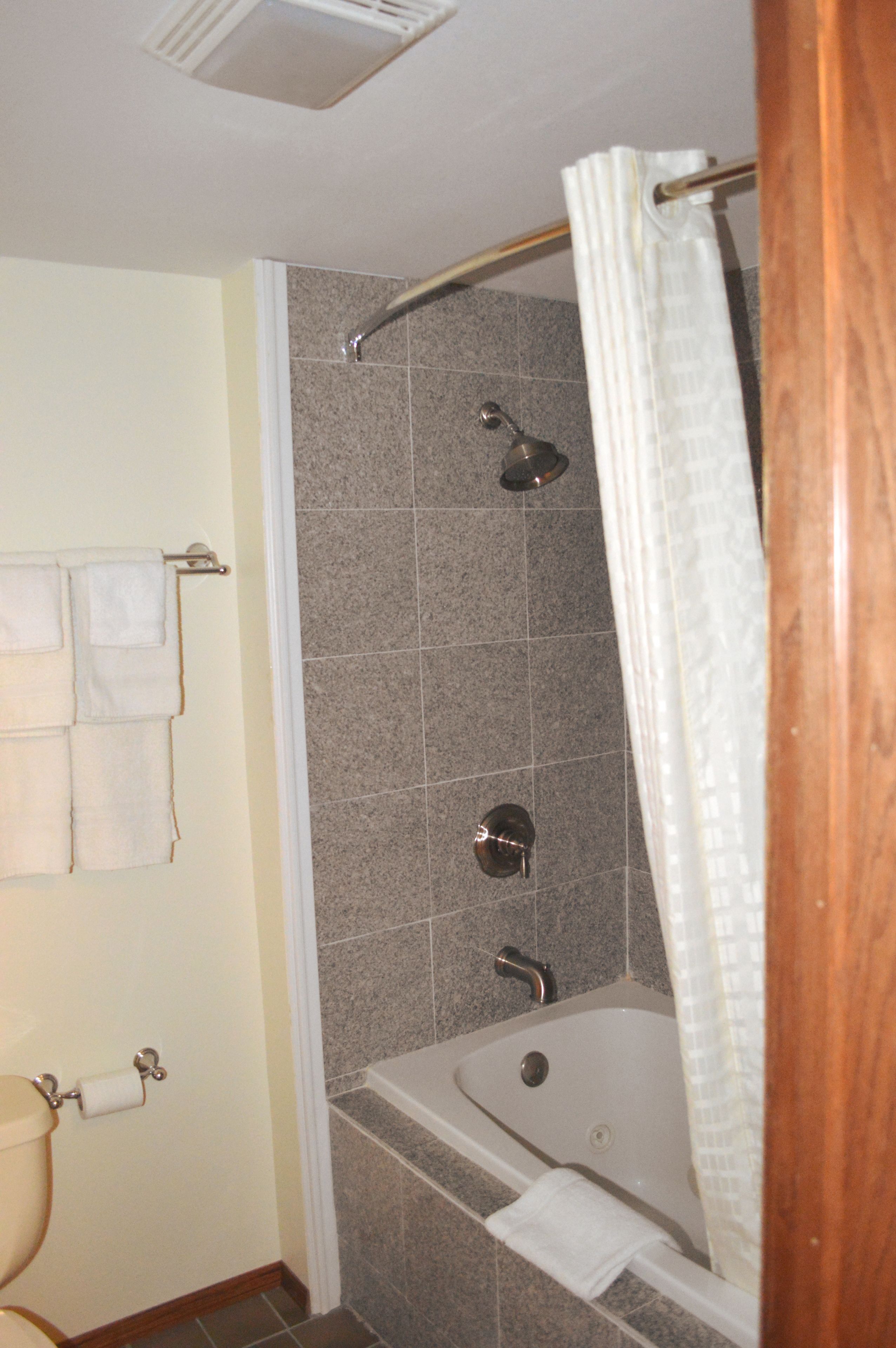 A bathroom with a bathtub, a shower, and a toilet.