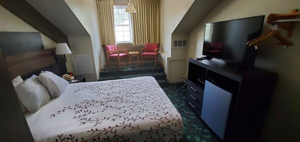 A hotel room with a bed, a TV, a desk, and a chair. - Roosevelt Inn Mount Rushmore (Keystone)