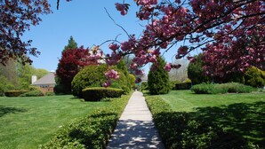 Un jardin bien entretenu, avec un chemin central menant à une maison.