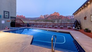A pool area with lounge chairs and a view of red rock formations. - Cedars Resort (Sedona)