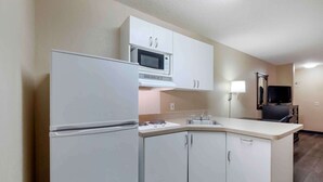 Una cocina funcional equipada con refrigerador, microondas y pileta.