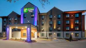 Ein Holiday Inn Express Gebäude mit modernem Design, das mehrere Eingänge und einen gut beleuchteten Eingangsbereich bietet.