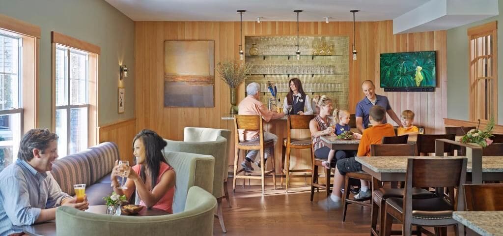 Un restaurant doté de plusieurs espaces de restauration, notamment un bar et une salle à manger avec des tables et des chaises.