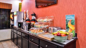 A buffet counter with a variety of food items, a coffee machine, and a toaster. - Quality Inn & Suites Beaumont (Beaumont)