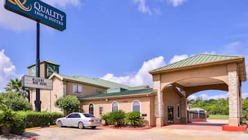 Welcome to Quality Inn & Suites, featuring a traditional architectural style and a beautifully landscaped entrance.