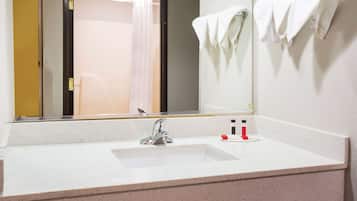 A bathroom with a white sink, a mirror, and a towel rack.