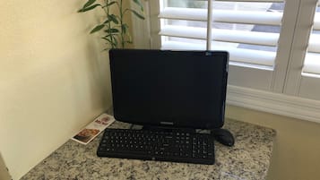 Una computadora de escritorio con teclado y monitor sobre una encimera de granito.