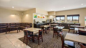 Een hotel lobby met een zithoek, een keuken en uitzicht op de stad.