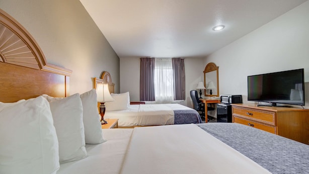 A hotel room with two beds, a television, a desk with a computer, and a window with curtains. - Econo Lodge Livingston Gateway to Yellowstone (Livingston)