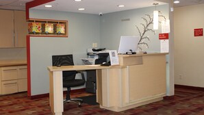 A reception desk with a computer, a chair, and a sign indicating a pet fee. - Sonesta Simply Suites Houston Brookhollow (Houston)