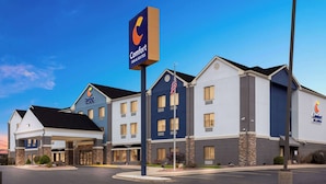 Un hotel Comfort Inn & Suites con un diseño moderno, que cuenta con una estructura de dos pisos, una entrada cubierta y un estacionamiento.