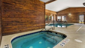 Ein Holzinnenraum mit Poolbereich, einschließlich eines Whirlpools und einem kleineren Pool.