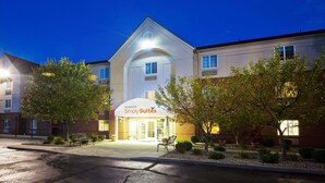 A hotel with a prominent entrance, a covered outdoor seating area, and a well-maintained garden. - Sonesta Simply Suites Detroit Troy (Troy)