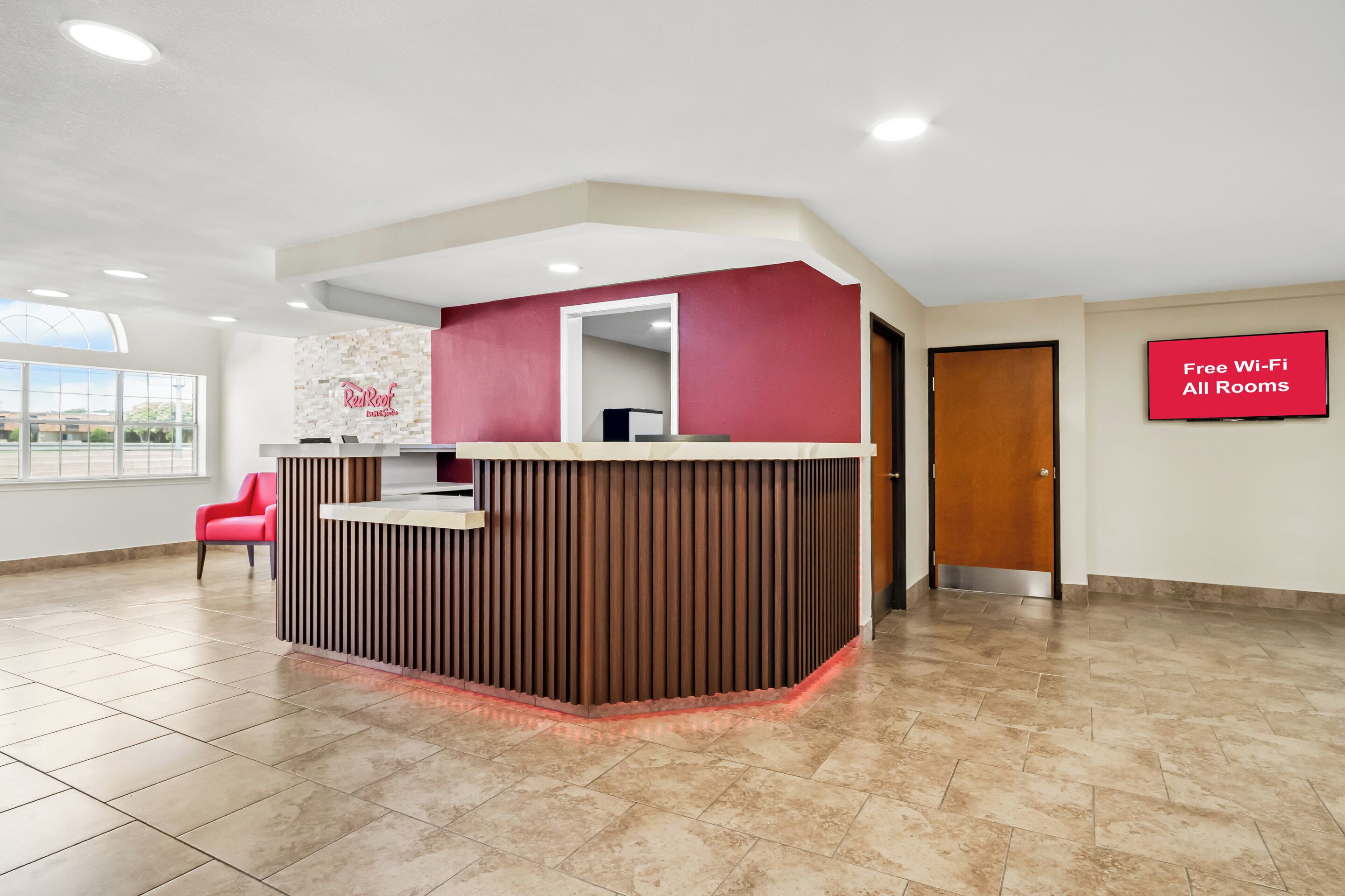 A reception area with a modern design, a red and white color scheme, and a sign indicating free Wi-Fi availability.