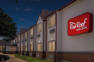 A Red Roof Inn & Suites building with multiple windows and a well-lit exterior.