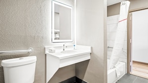 Ein modernes Badezimmer mit Waschbecken, Spiegel und Toilette in Weiß.