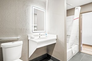 A modern bathroom with a white sink, mirror, and toilet. - Red Roof Inn & Suites Euless - DFW Airport Southwest (Euless)