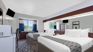 A hotel room with two beds, a TV, a refrigerator, and a window with curtains. - Microtel Inn & Suites by Wyndham London (London)