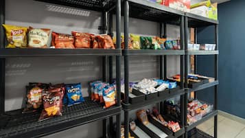 A shelf stocked with various snack brands including Lay's, Ruffles, and Doritos.