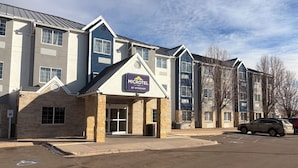 A Microtel Inn by Wyndham building with a brick facade, large windows, and a parking lot.