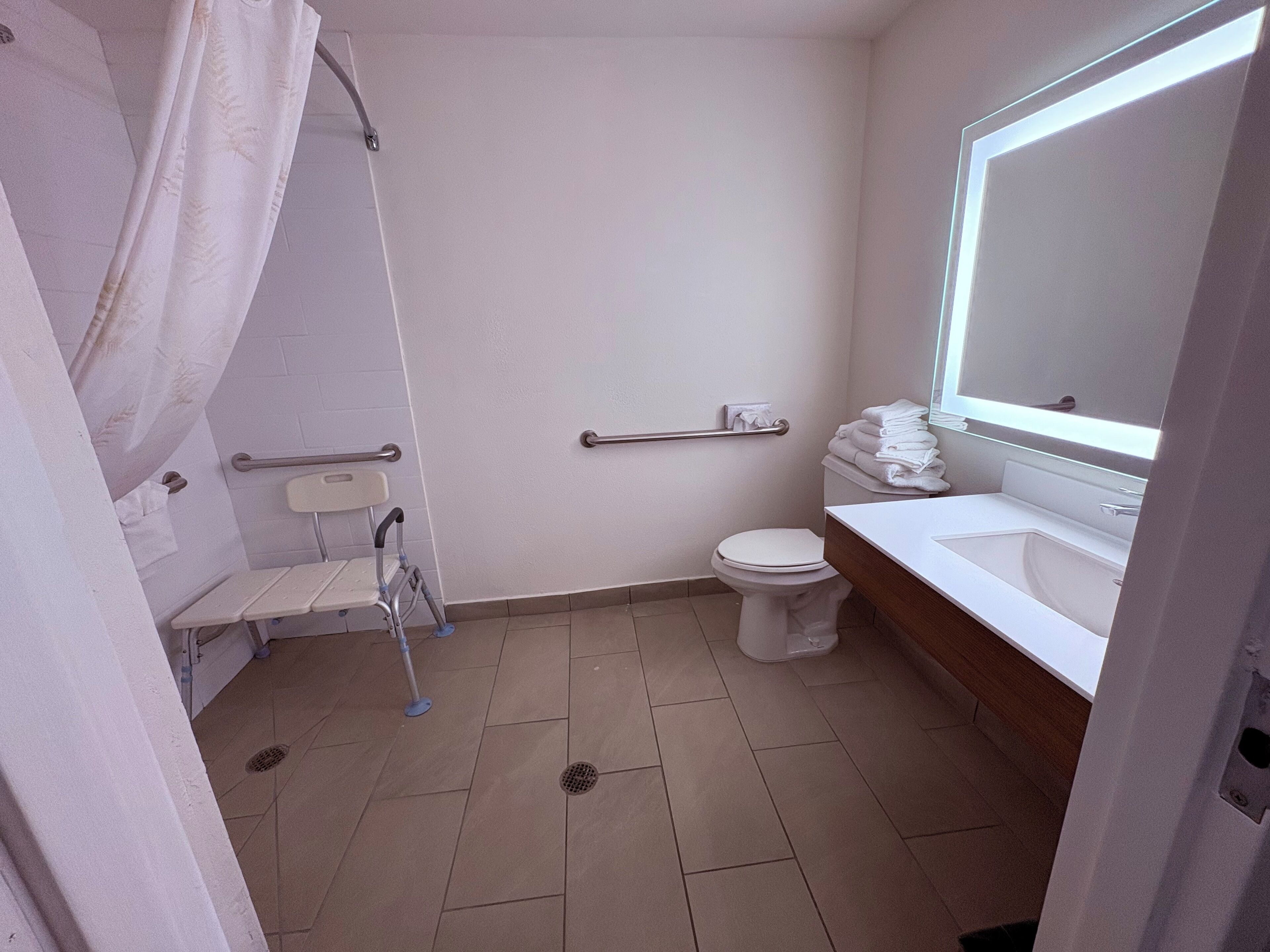 A bathroom with a shower, toilet, and sink.