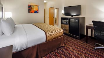 Une chambre d’hôtel équipée d’un lit, d’un bureau, d’une télévision et d’un mini-bar.