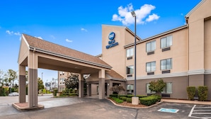 Ett Best Western-hotell med en inglasad entré, flera fönster och en parkeringsplats med en parkeringsplats reserverad för rörelsehindrade.