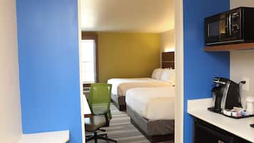 Une chambre d’hôtel équipée d’un bureau, d’un four à micro-ondes, d’une machine à café et de deux lits.
