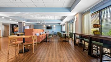 A spacious indoor area with wooden flooring, seating arrangements, and a bar counter.