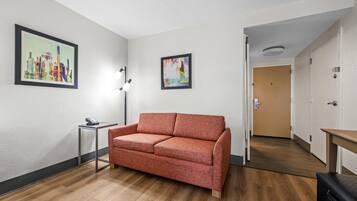 A room with a sofa, a small table, and two framed pictures on the wall.