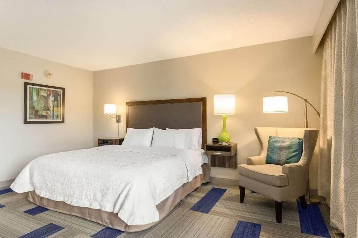 Escritorio, cortinas blackout y tabla de planchar con plancha