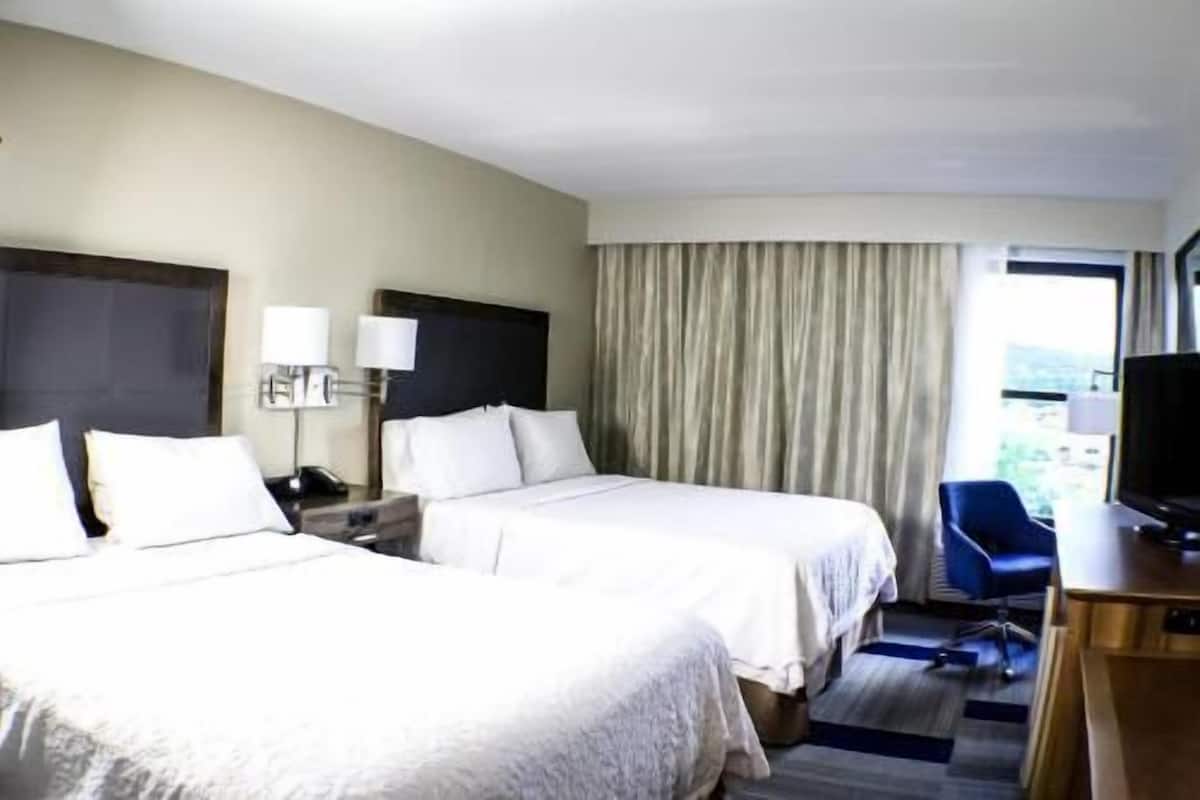 Escritorio, cortinas blackout y tabla de planchar con plancha