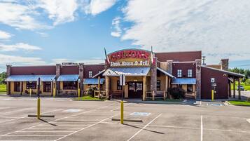 A steakhouse with a parking lot and a building with a sign reading "Colton's Steak House & Grill".