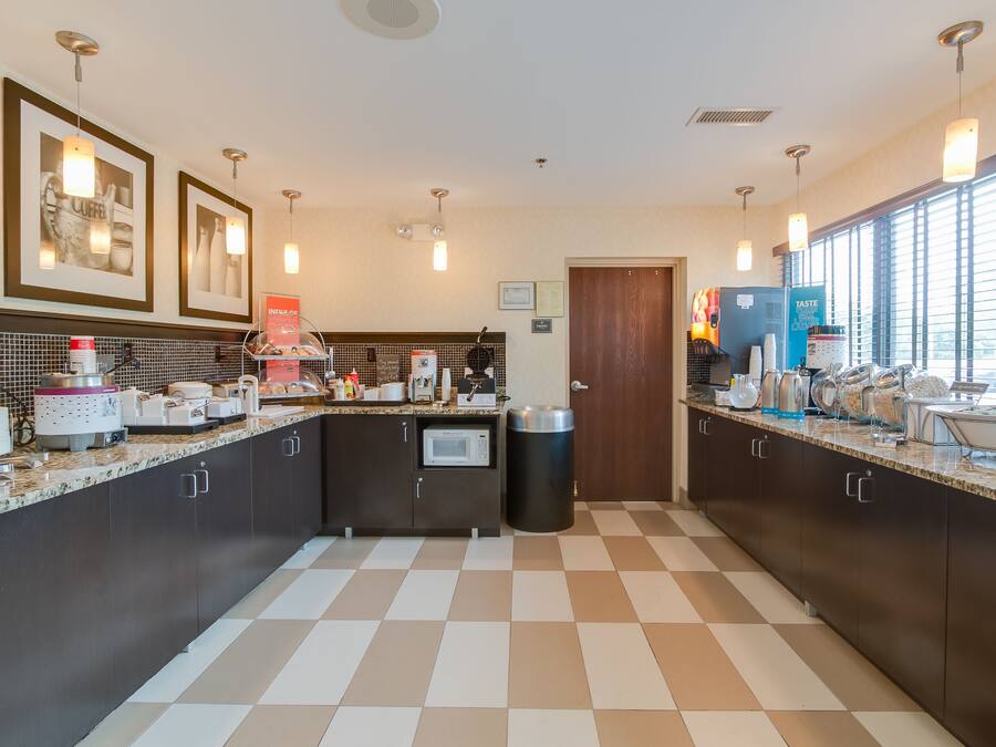 A modern kitchen with dark cabinets, a microwave, and a coffee machine.