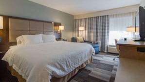 A hotel room with a large bed, a desk, a chair, a TV, and a window with curtains. - Hampton Inn Bellevue / Nashville-I-40 West (Nashville)